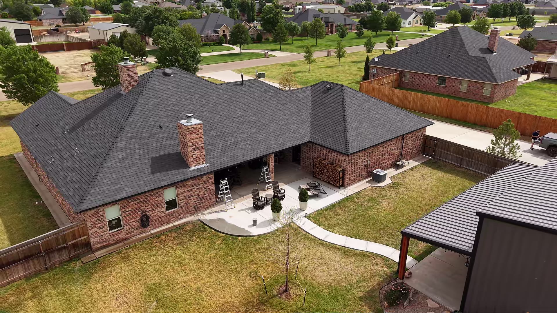 MagnaTrack screens lowered around a covered patio on a brick home