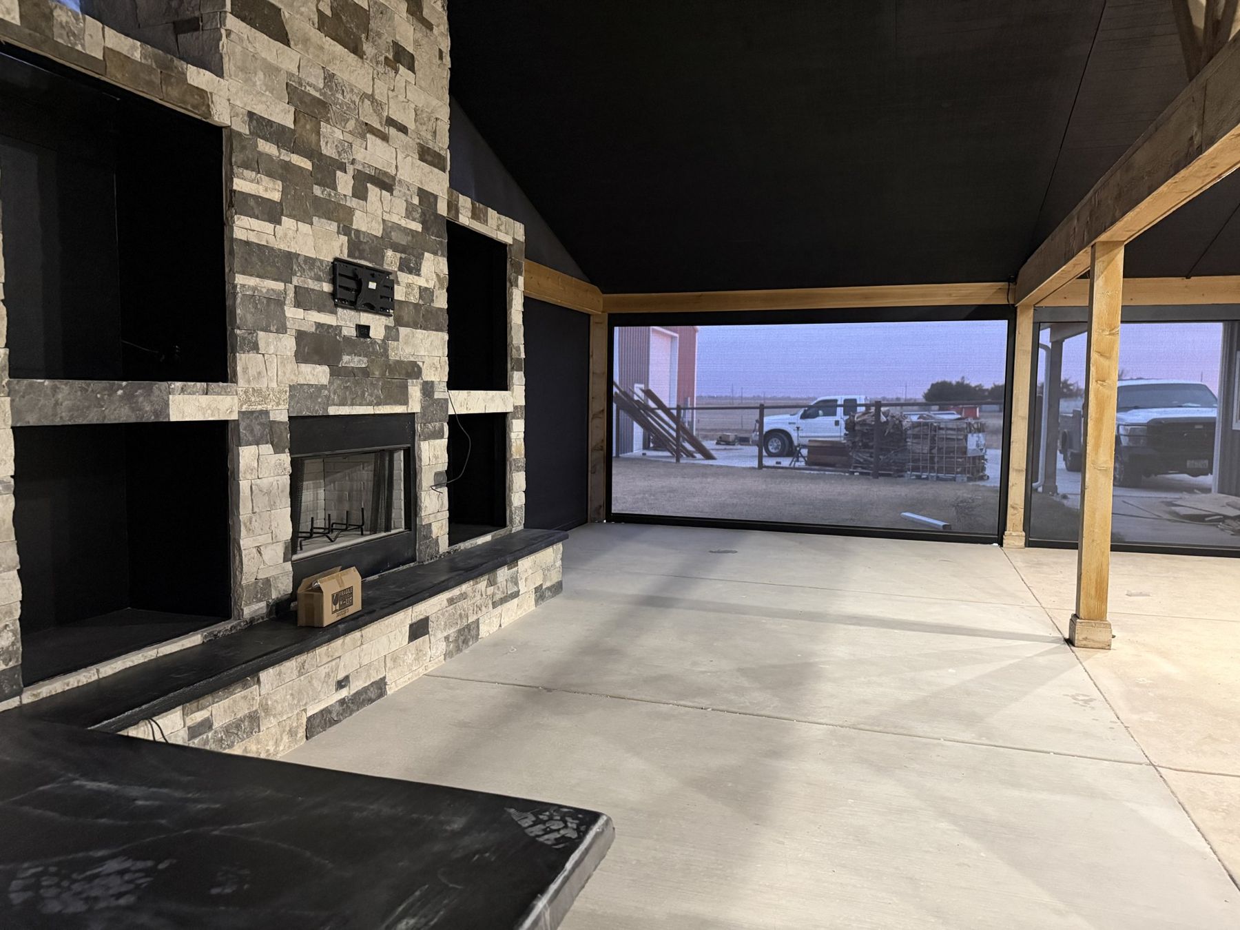 Screened outdoor living room with stone fireplace