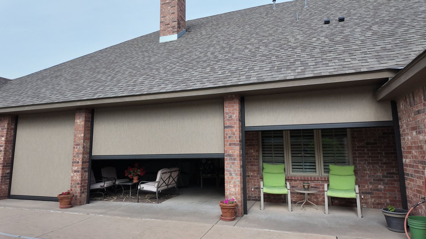Tan screens partly lowered on a brick patio