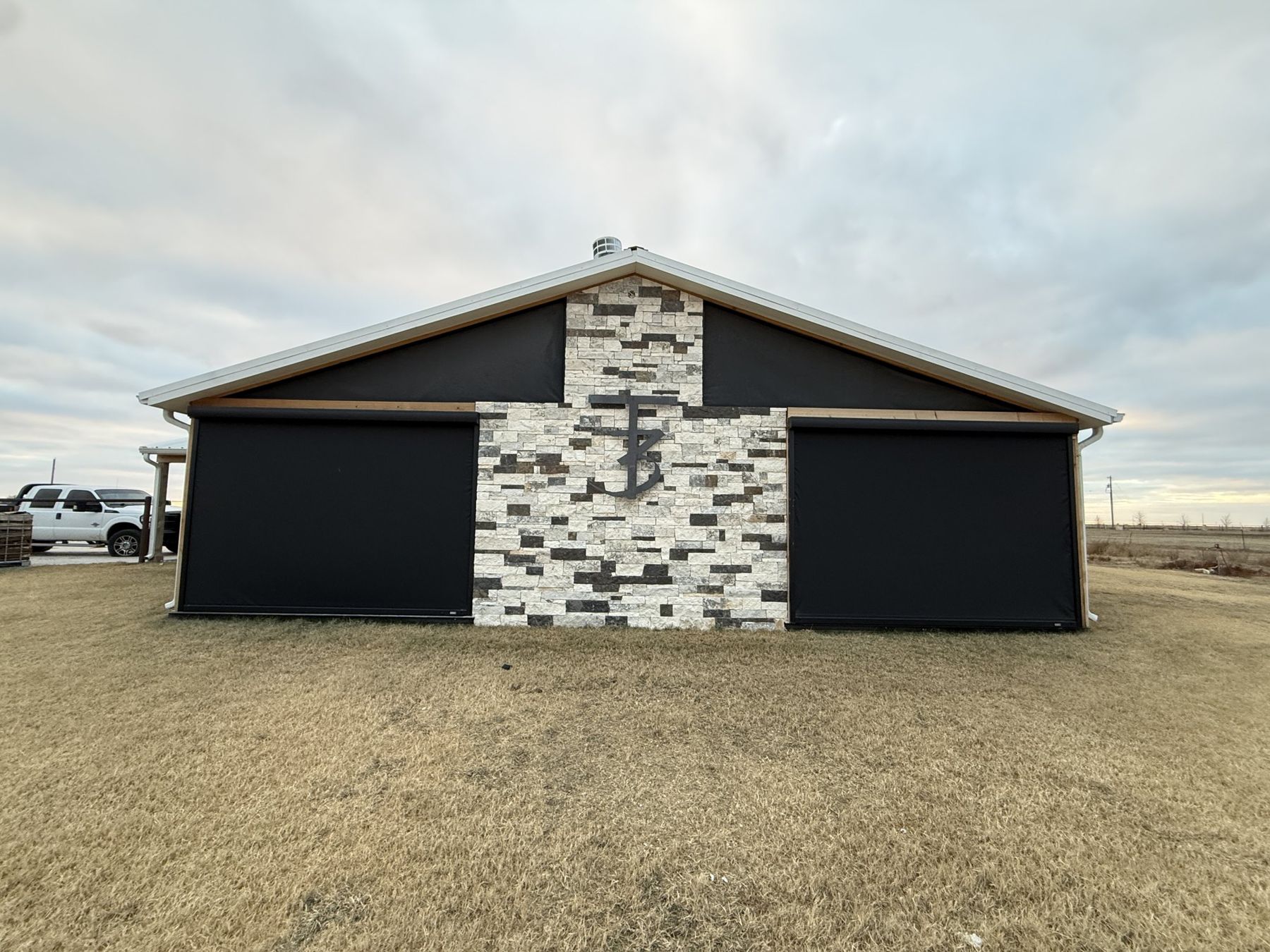 Black screens on a stone and metal barn