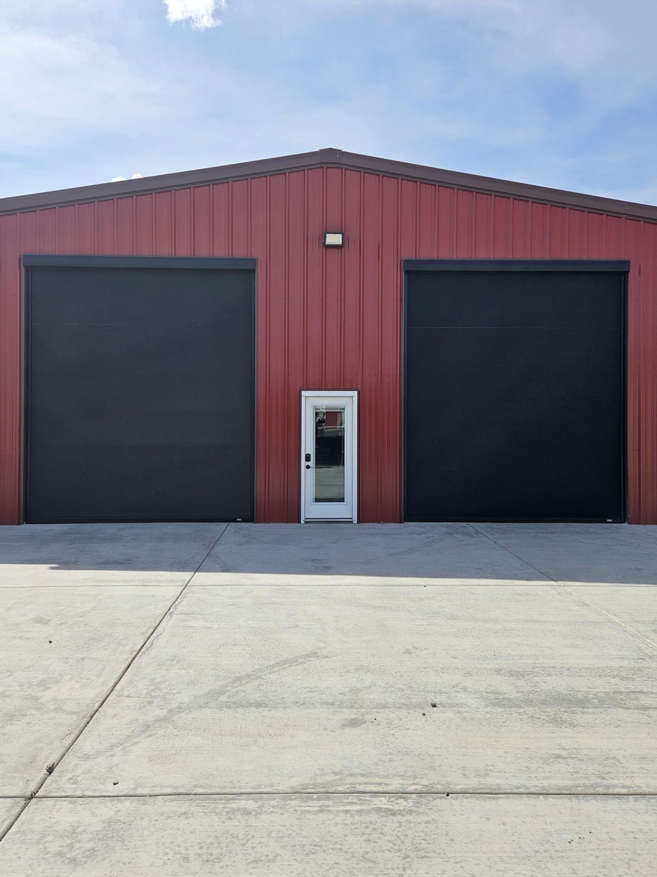 Oversized screens on a red metal shop